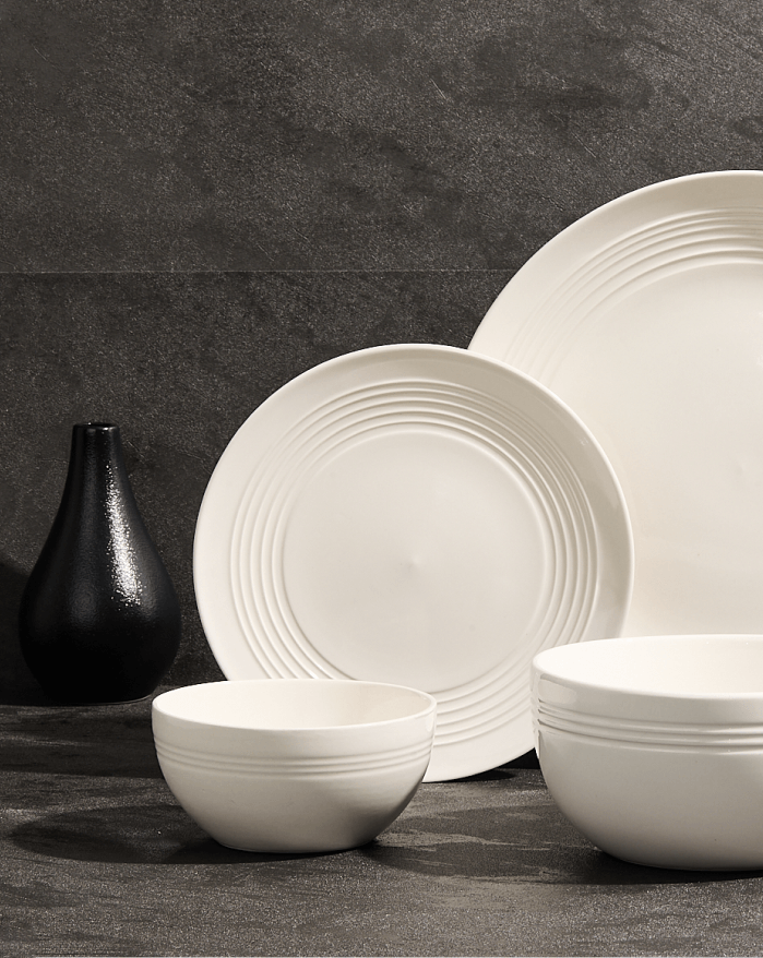 A white dinner set featuring a bowl and a plate arranged elegantly on a table